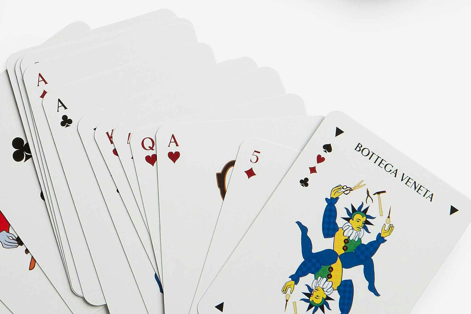 A set of Bottega Veneta playing cards with green backsides and a red case